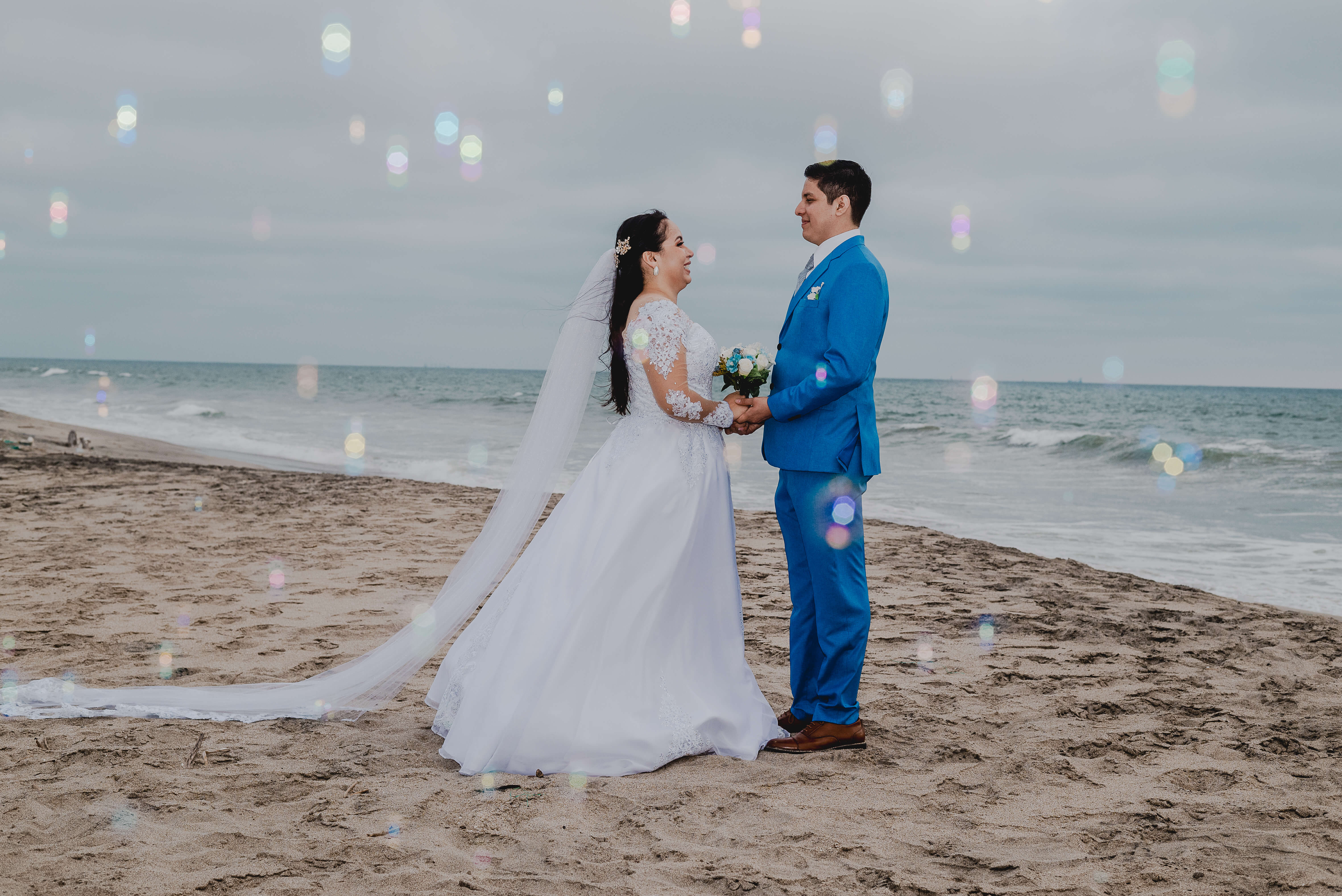 Kattya y Freddy tomados de la mano frente al mar durante su boda en Karibao, Playas.