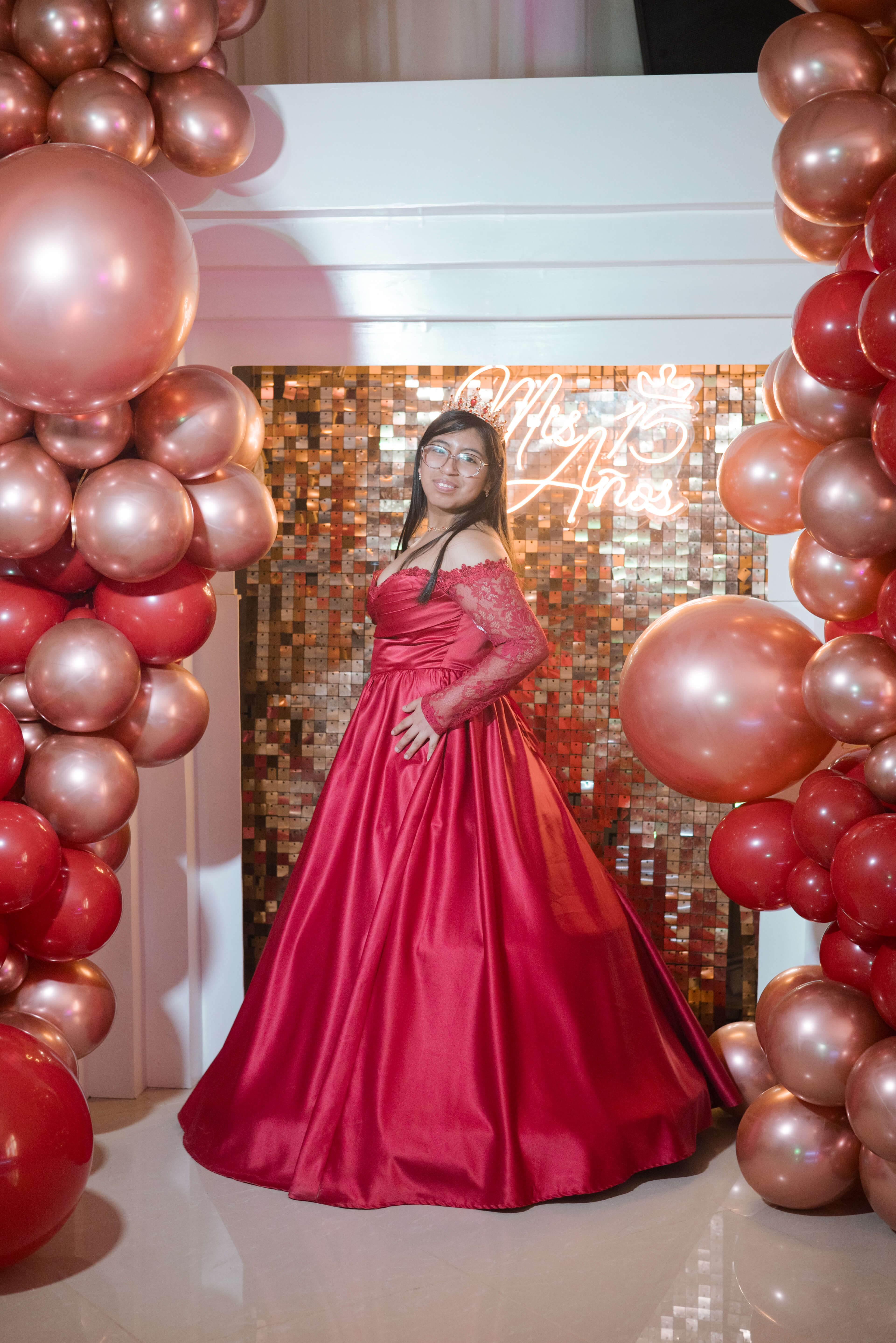 Camila posando feliz y luciendo los detalles de su elegante vestido de XV años.