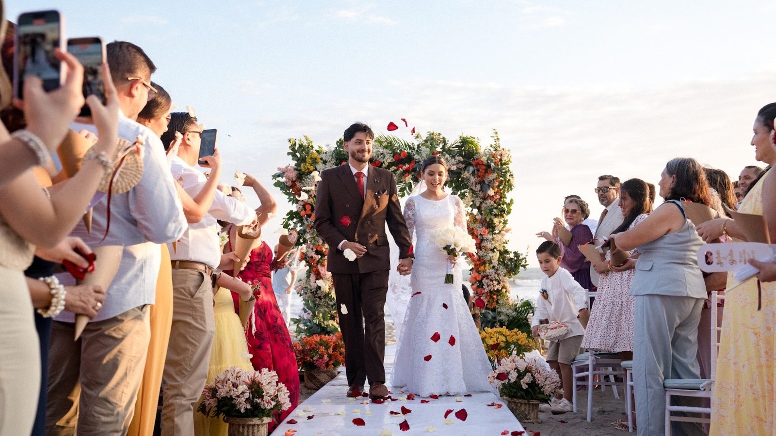 Novios caminando entre sus invitados durante su boda en la playa