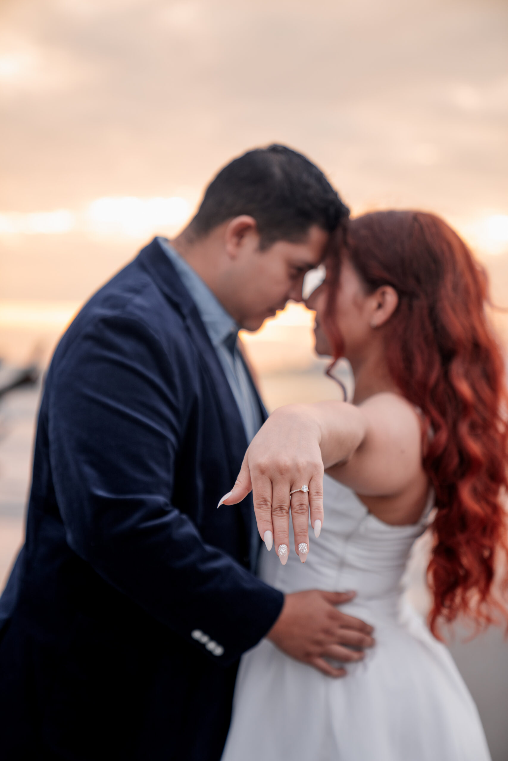Pareja de novios en un momento de conexión mostrando el anillo de compromiso.